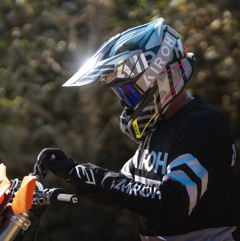 Rider wearing Airoh Strycker helmet with goggles on an off-road motorcycle