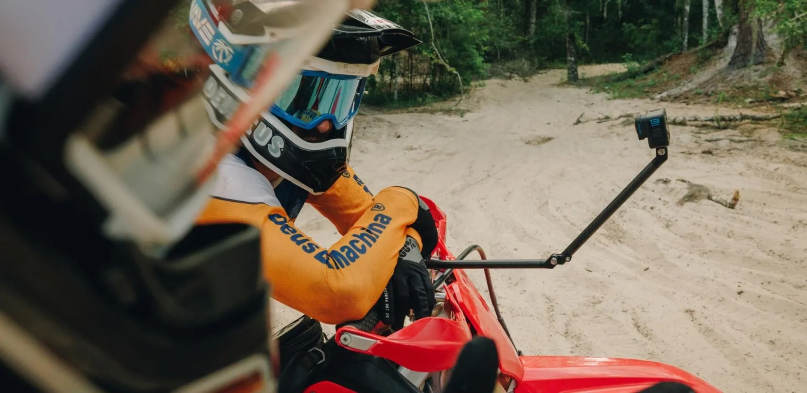 Motorcyclist using a boom arm to mount an action camera for side-angle footage