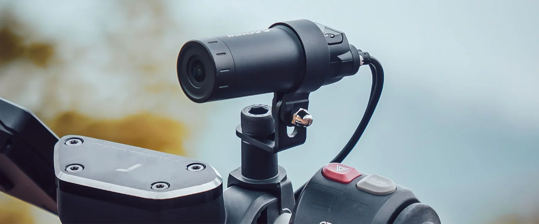 Close-up of INNOVV dash cam mounted on motorcycle handlebar with wired setup