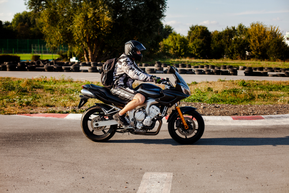 Motorcyclist in helmet and camo jacket riding a sport-touring bike on a track