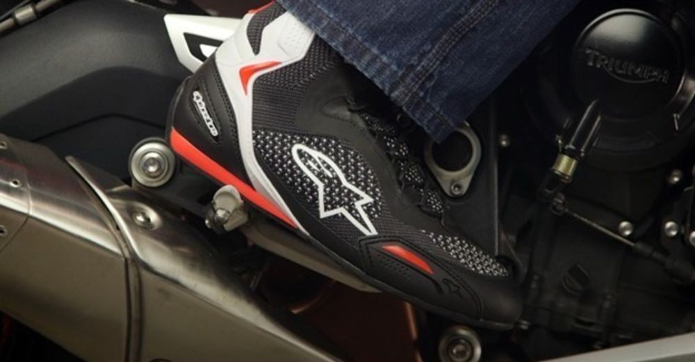 Close-up of Alpinestars Faster-3 Rideknit Shoes on footpeg of a Triumph motorcycle
