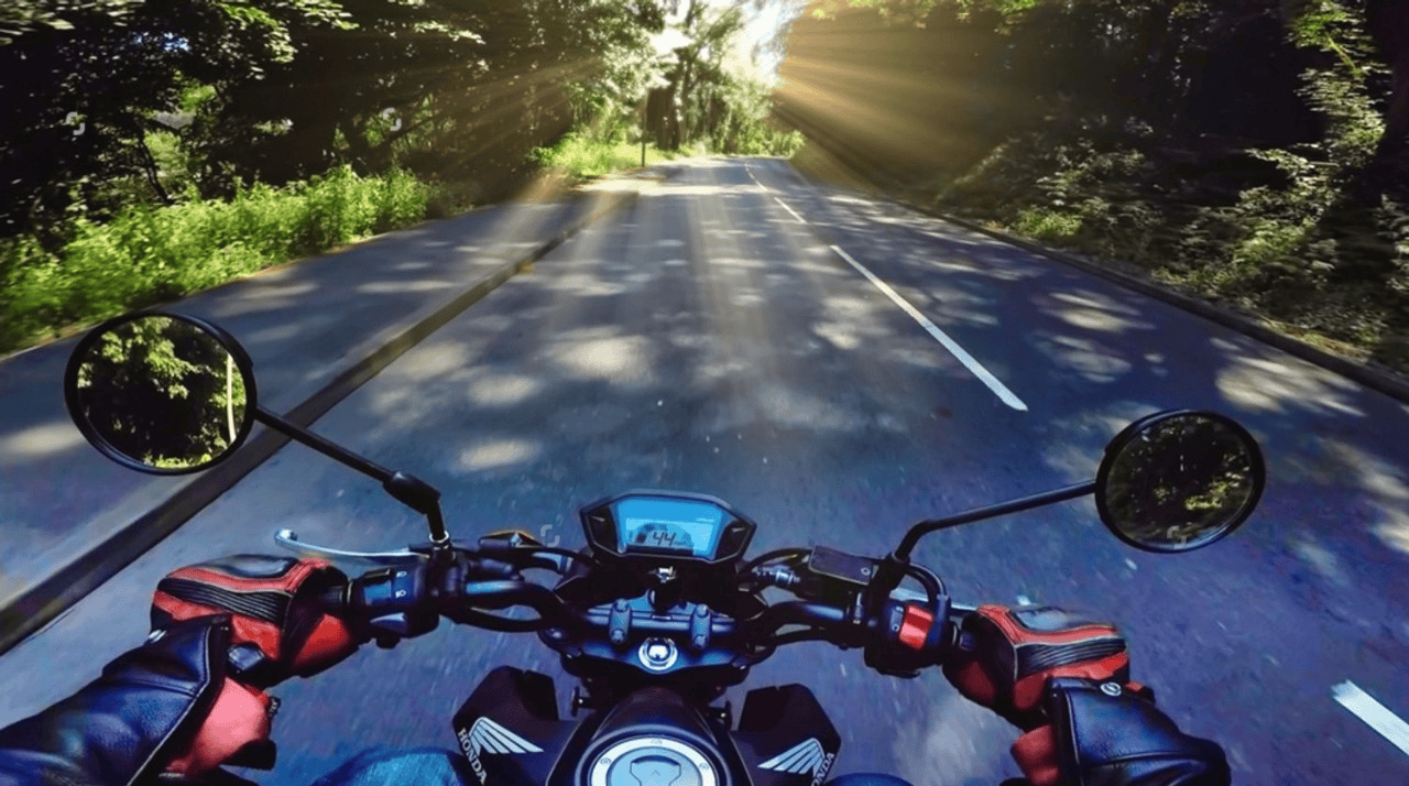 Motorcyclist capturing scenic road footage using an action camera POV