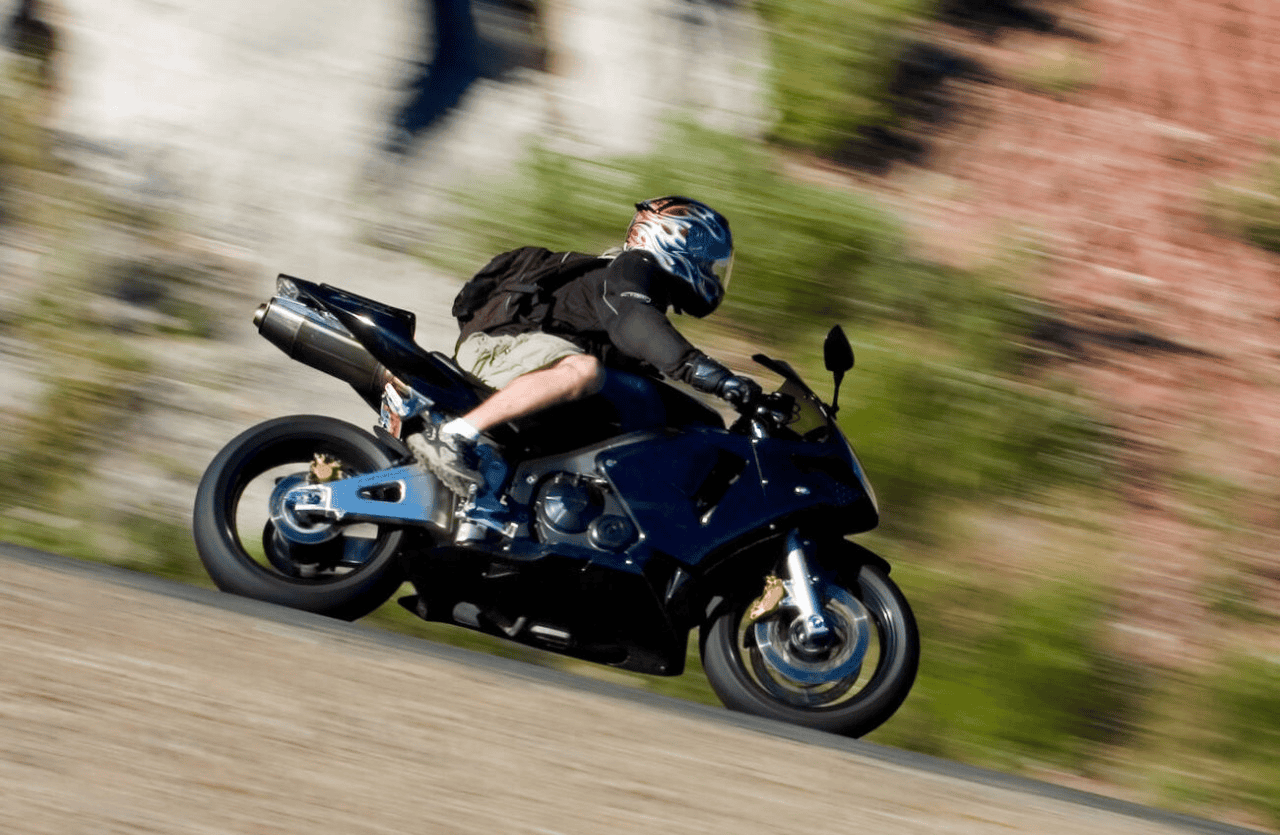 Motorcyclist riding at speed in shorts and a t-shirt without proper protective gear