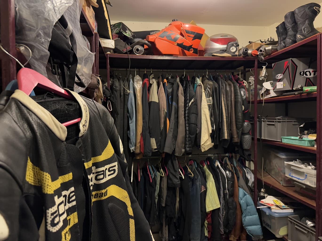 Closet full of motorcycle jackets, helmets, and gear in storage