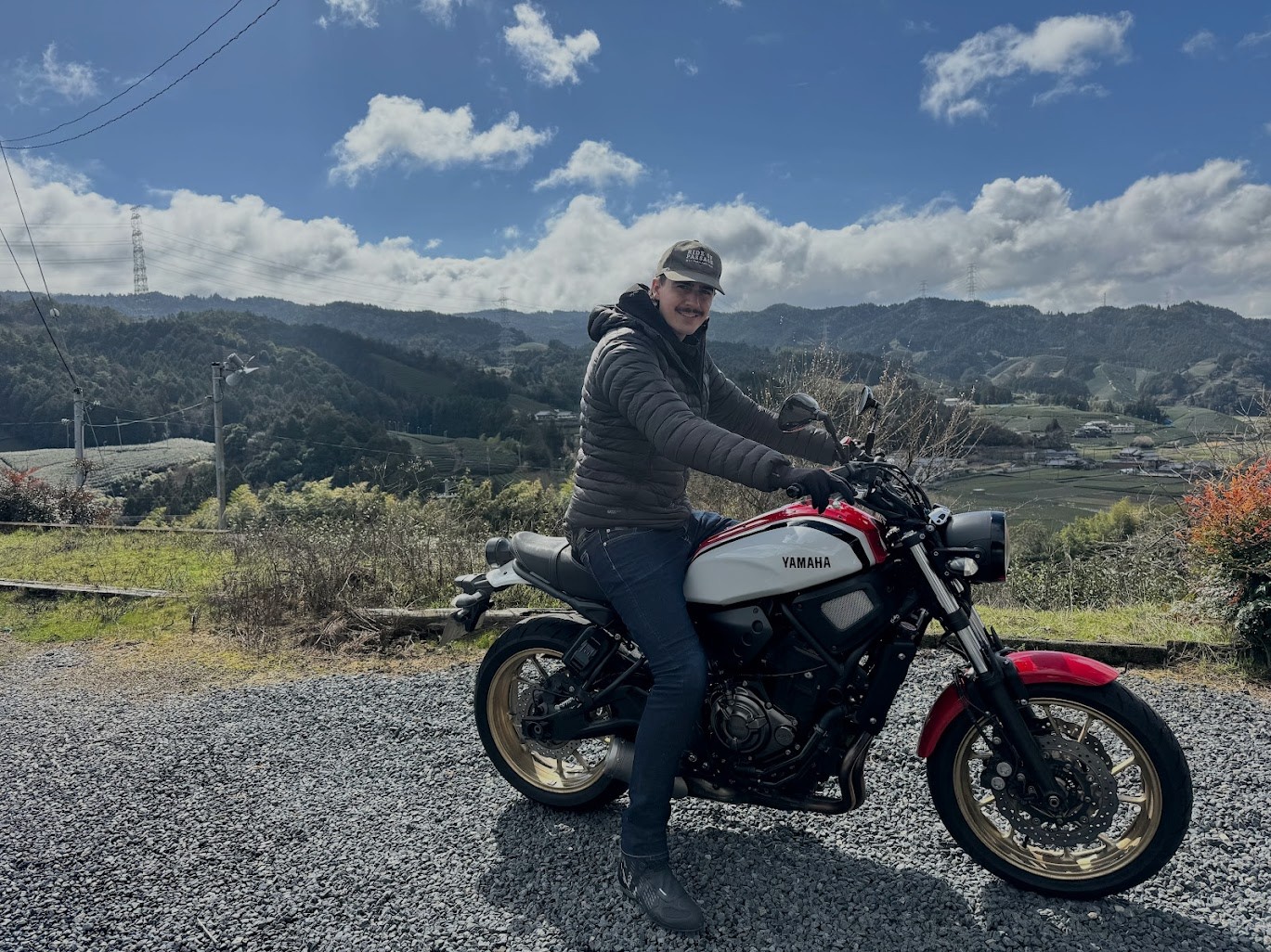 Motorcyclist on a bike with a scenic mountain backdrop on a clear day.