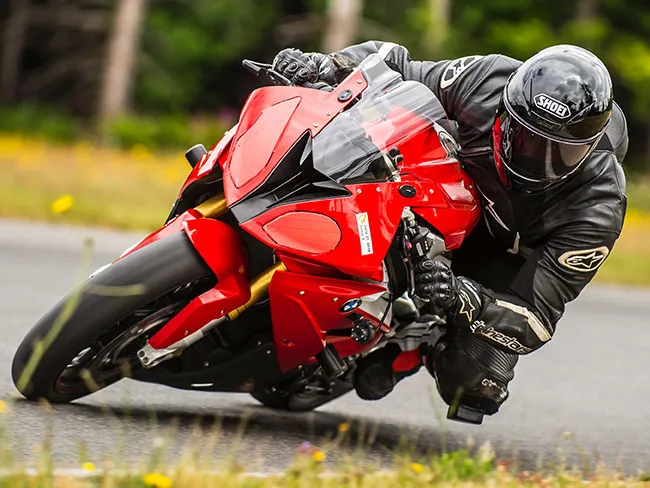 Motorcyclist leaning into a corner on a sport bike equipped with Thinkware M1 dash cam