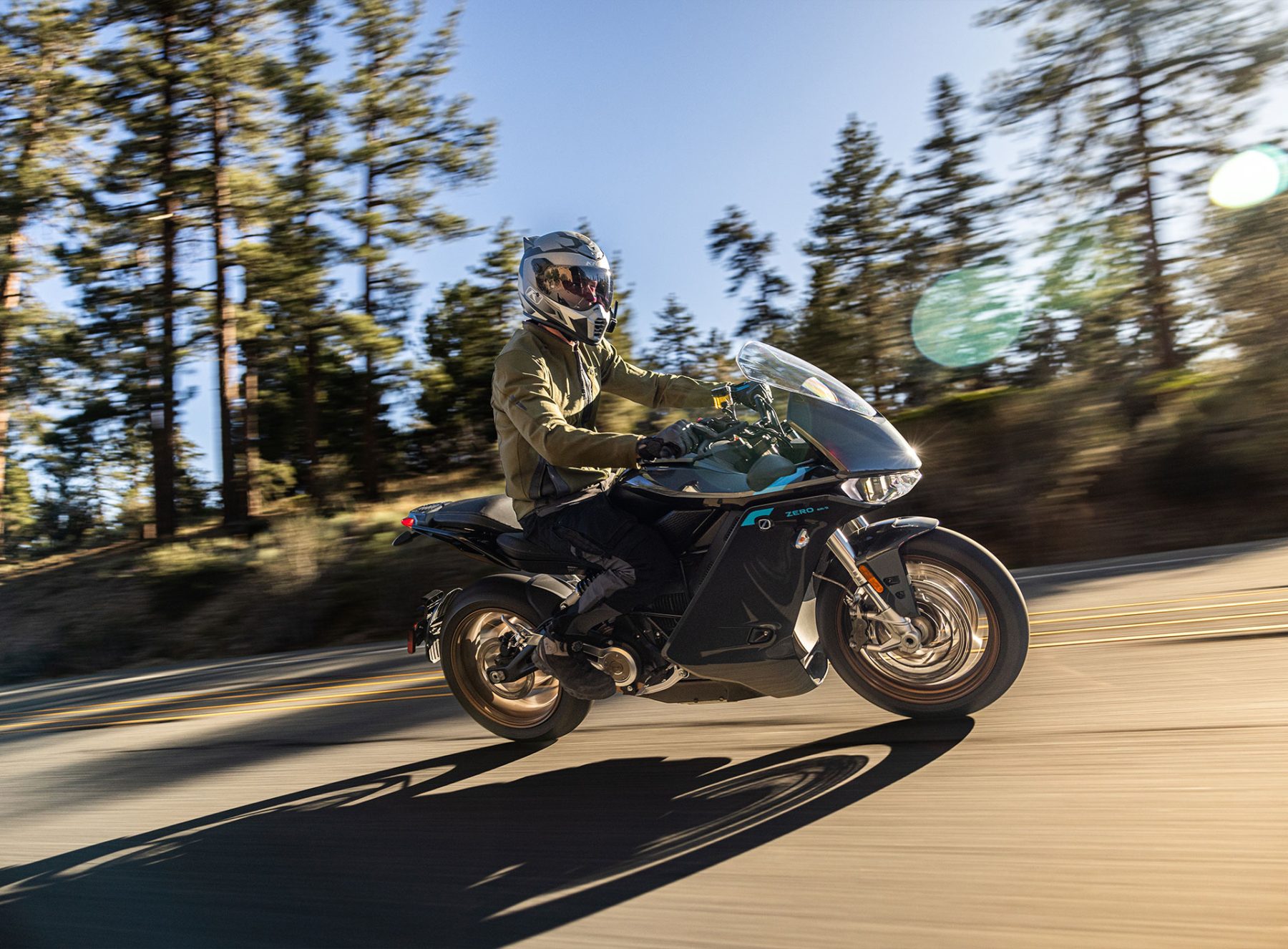 Rider wearing the Klim Marrakesh Jacket on a sport-touring motorcycle through a forested mountain road