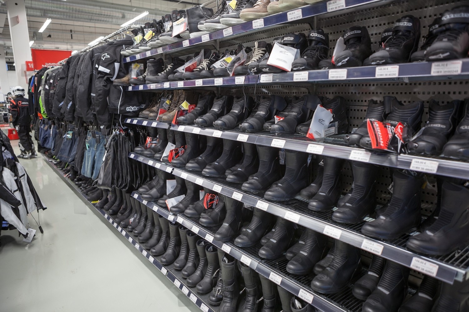 Motorcycle boots and riding gear displayed on shelves inside a retail store