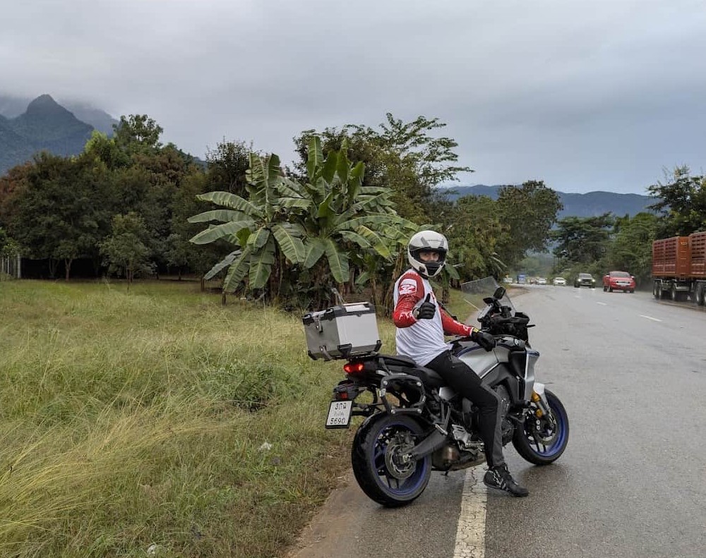 Motorcycle rider in full gear giving a thumbs up, showing riding boots that blend safety and style.