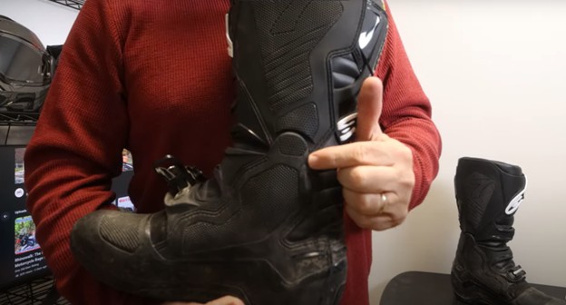 Rider pointing to the hinge mechanism on a motocross boot