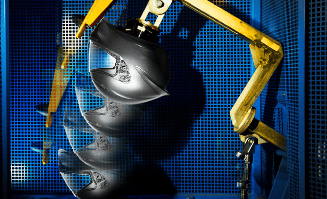 Helmet undergoing impact test in lab setup, illustrating ECE 22.06-style crash simulation.