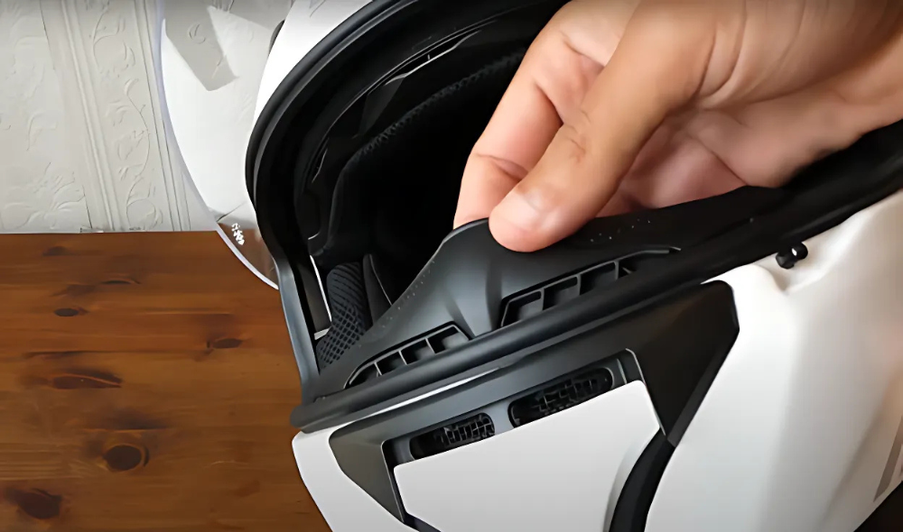 Hand adjusting breath deflector inside the Sena Stryker helmet