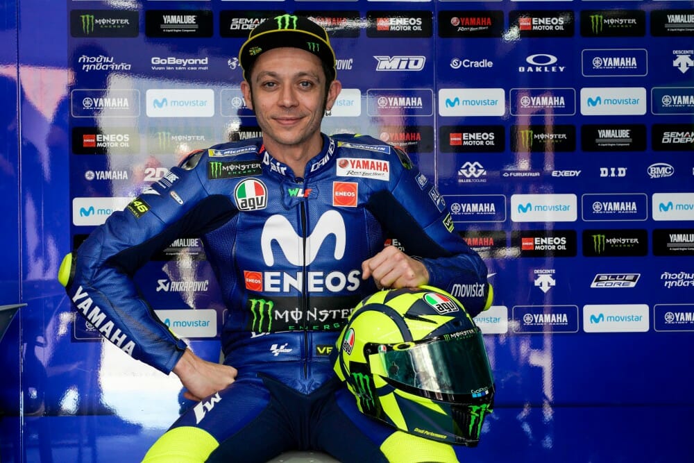 Valentino Rossi holding his AGV Pista GP R helmet in the garage.
