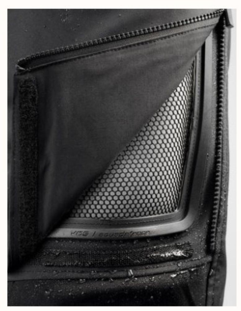 Close-up of the VCS Aquadefence vent on REV'IT! Dominator 3 GTX Pants, showing waterproof zip and mesh airflow panel.
