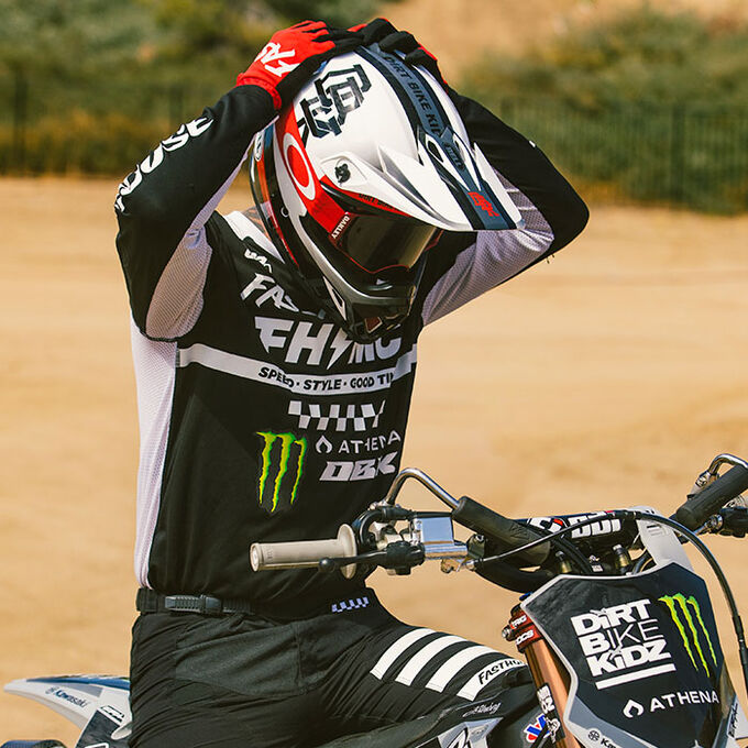 Dirt bike rider wearing a Bell MX-9 helmet and adjusting it before a ride