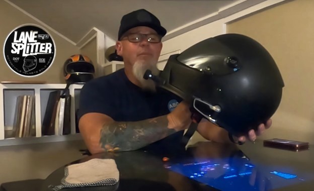 Rider holding Biltwell Lane Splitter helmet while discussing internal speaker and comms fit