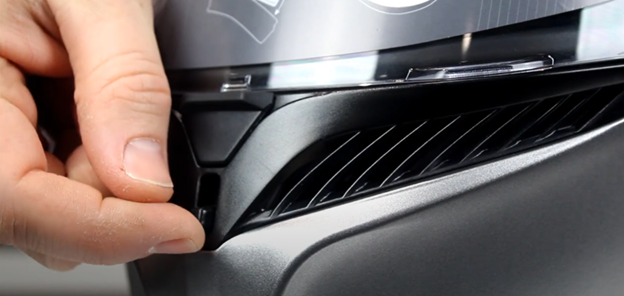 Close-up of a hand adjusting the external chin vent on the AGV K3 helmet
