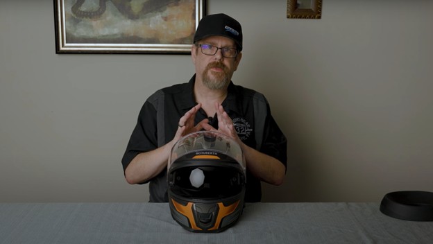 Rider demonstrating the drop-down sun visor on the Schuberth S3 helmet
