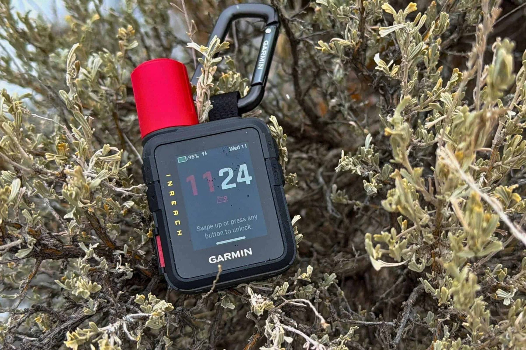 Garmin inReach Mini 3 satellite communicator attached to gear in outdoor terrain