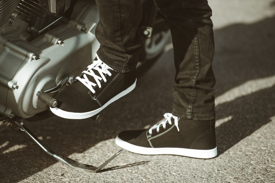 Close-up of a rugged motorcycle riding shoe showing reinforced toe and heel areas, styled like a casual boot