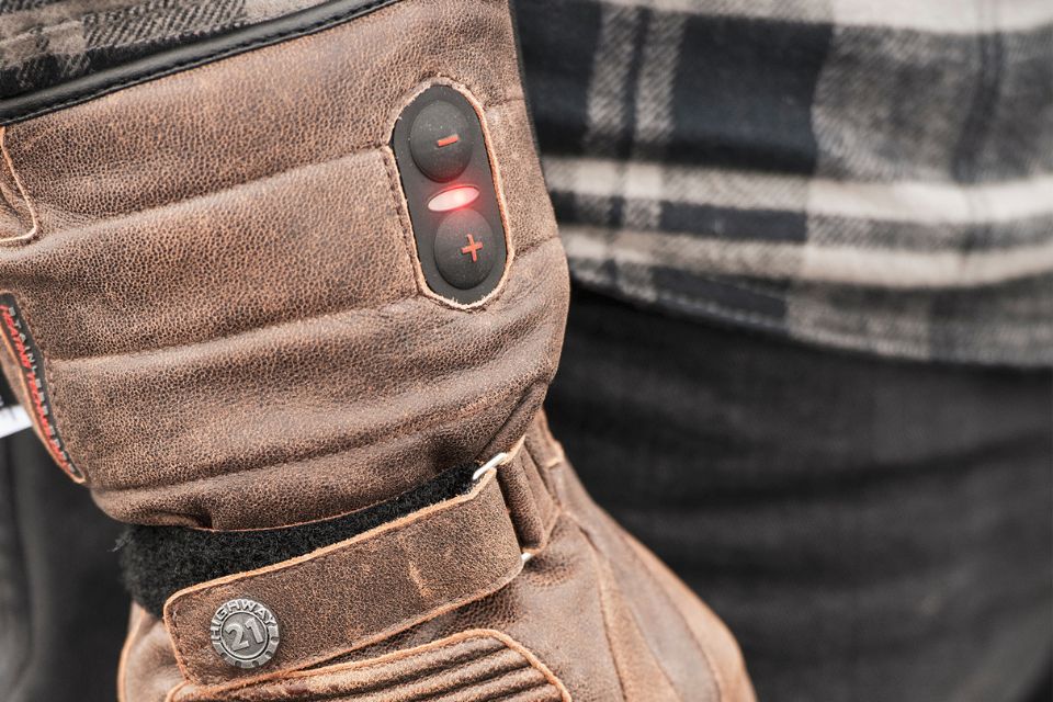 Heated motorcycle glove with visible heat control buttons and red indicator light.