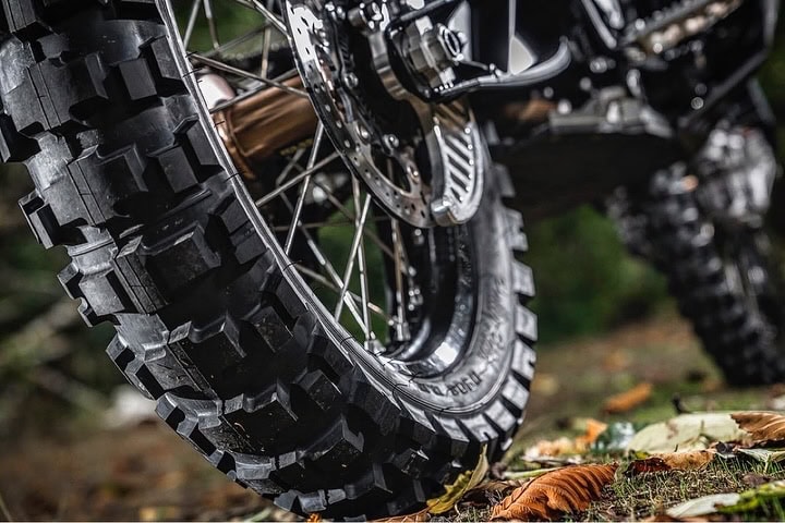 Close-up of an aggressive off-road motorcycle tire on forest floor
