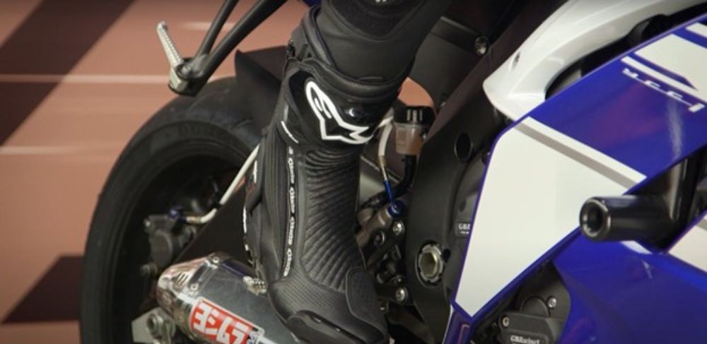 Close-up of a rider wearing Alpinestars SMX Plus v2 Vented Boots on a sportbike, showing perforated panels and ankle support.