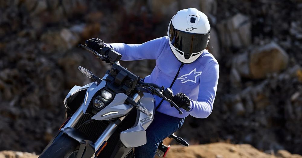Woman riding a motorcycle in the Alpinestars Stella Chrome V2 Hoody, designed for casual style with built-in urban riding protection.