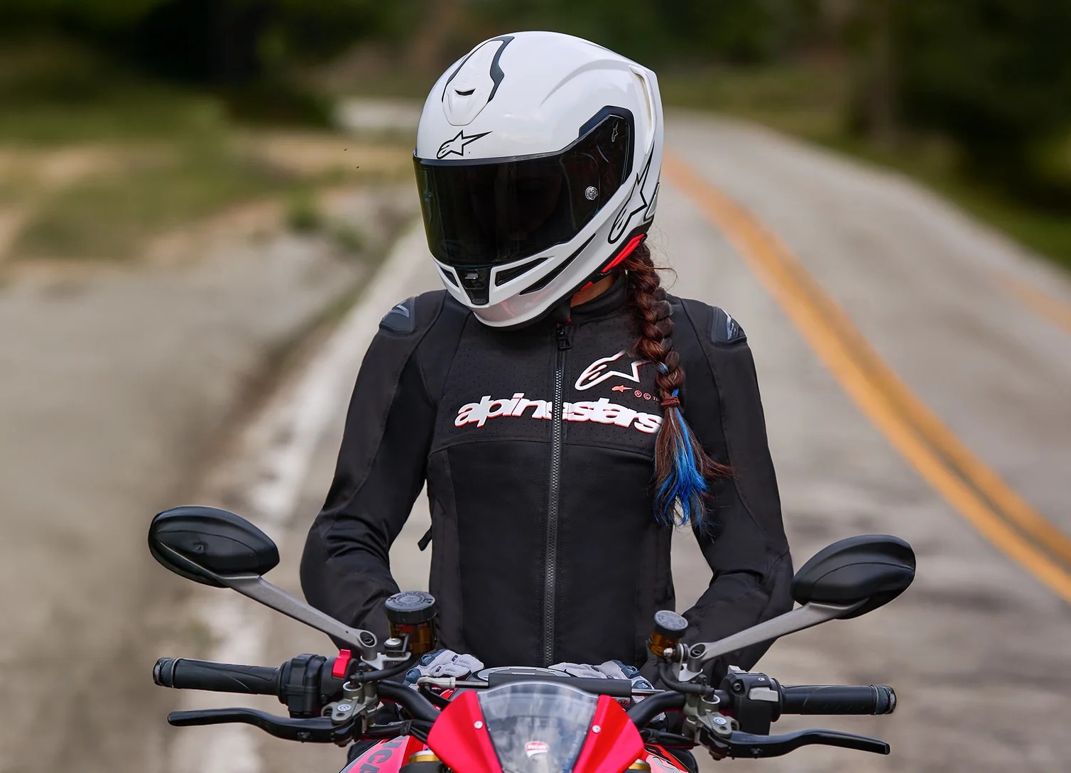 Woman rider wearing Alpinestars Stella SMX Air mesh motorcycle jacket on a sport bike