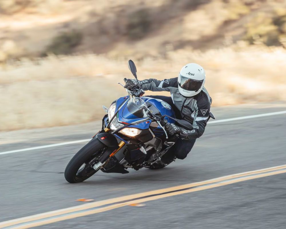 Motorcyclist wearing an Arai Signet-X helmet cornering on a mountain road