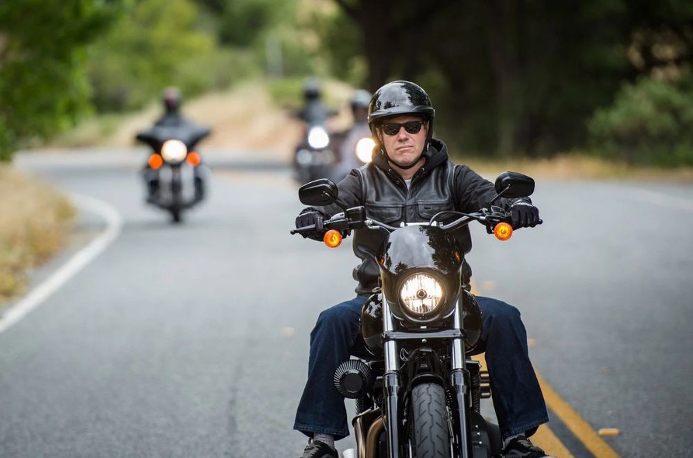 Motorcyclist leading a group ride while wearing a Bell Pit Boss half helmet and sunglasses