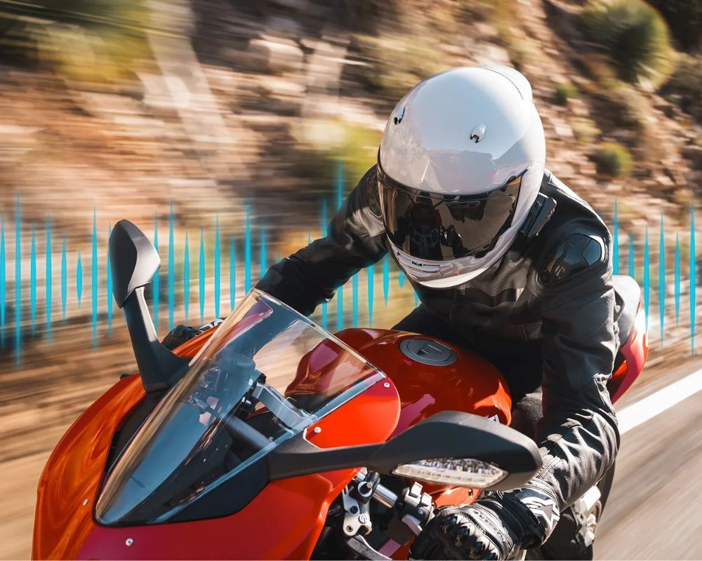 Sportbike rider using a Cardo Packtalk Pro headset, demonstrating aerodynamic helmet setup and premium noise-canceling tech at speed