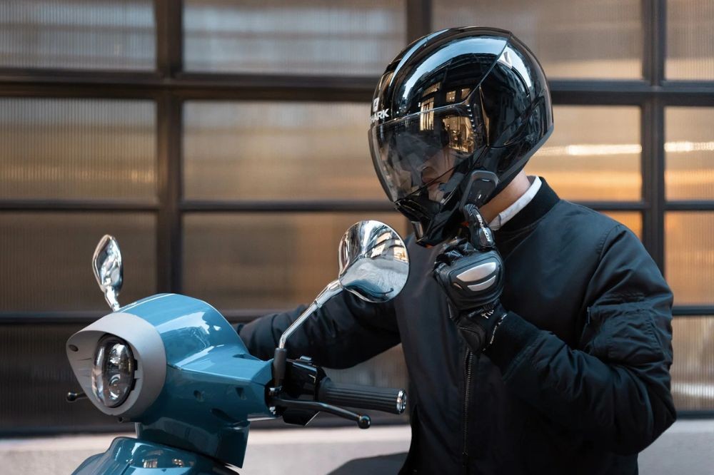 Rider using Cardo Spirit Bluetooth headset while stopped on a scooter