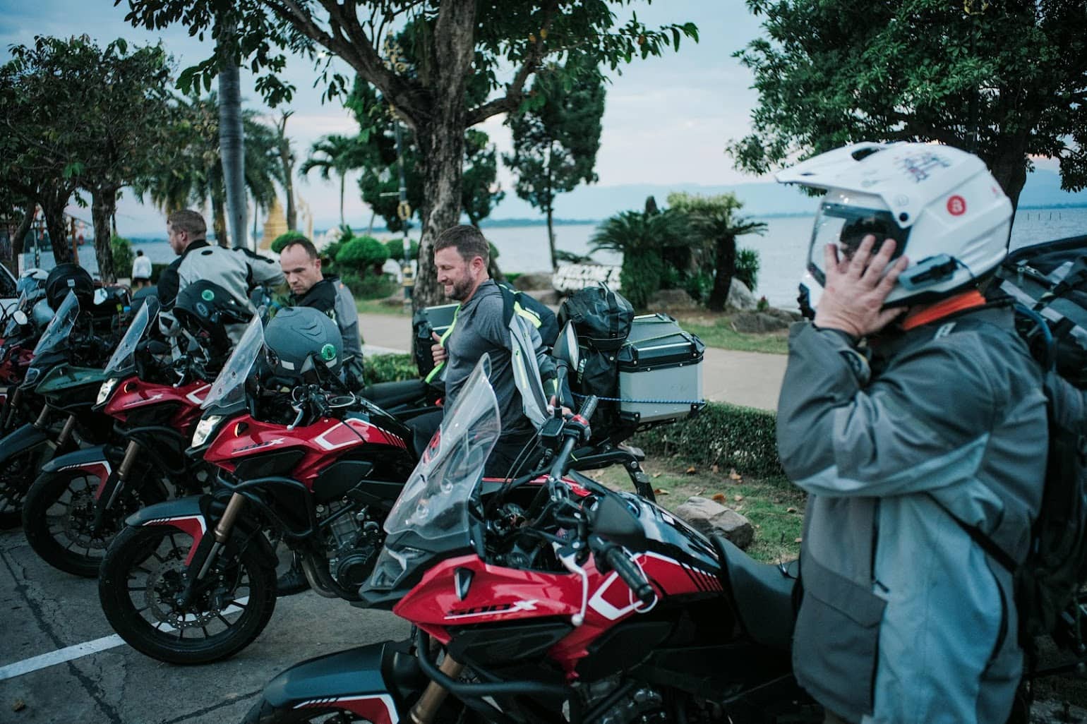 Group of adventure motorcyclists preparing for a ride, wearing full protective gear with touring motorcycles