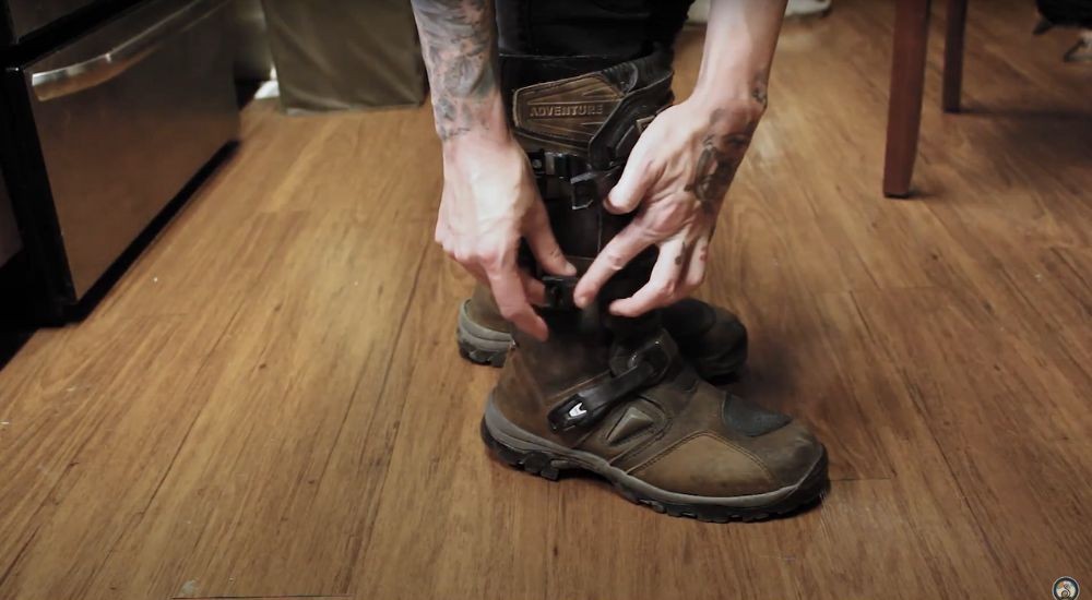 Adjusting the buckles on a worn pair of Forma Adventure Boots indoors