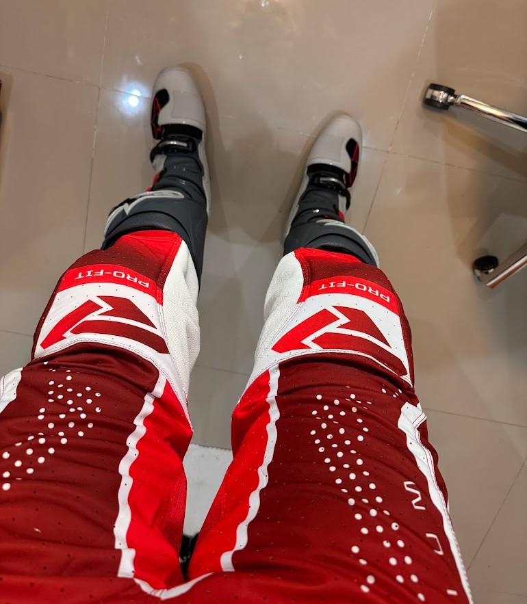 Top view of new motocross boots and gear being broken in indoors before riding.