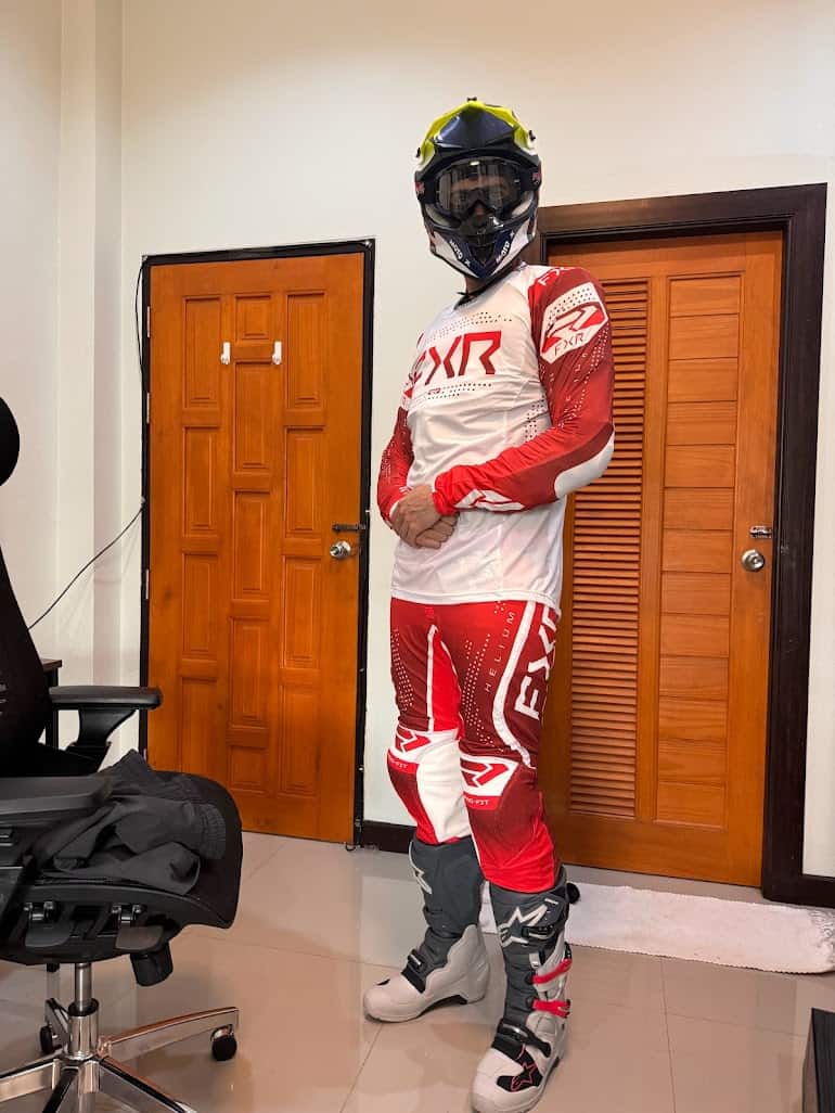 Rider in full FXR motocross gear and Alpinestars Tech 7 boots, standing indoors and geared up for enduro riding.