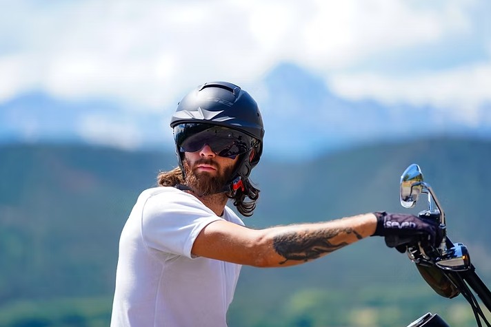 Rider wearing the LS2 Rebellion half helmet with sunglasses on a cruiser bike in the mountains
