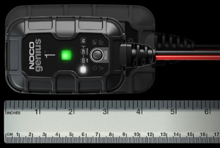 NOCO GENIUS1 1A smart charger with ruler for scale, showing compact size and dual charging cables.
