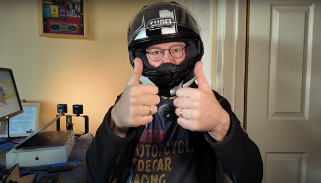 Man wearing Shoei GT-Air 3 helmet with glasses, giving thumbs up indoors