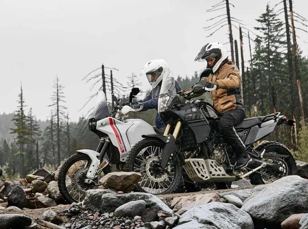 Two adventure riders navigating rocky terrain, highlighting the importance of ankle and foot protection in off-road boots.