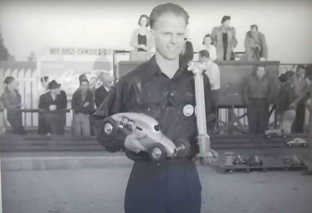 Vintage photo of Roy Richter holding a trophy and model race car