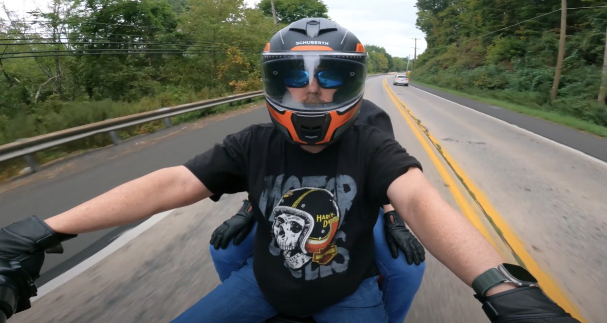 Rider wearing Schuberth S3 helmet on the road, hands on handlebars, showing helmet stability and visor clarity