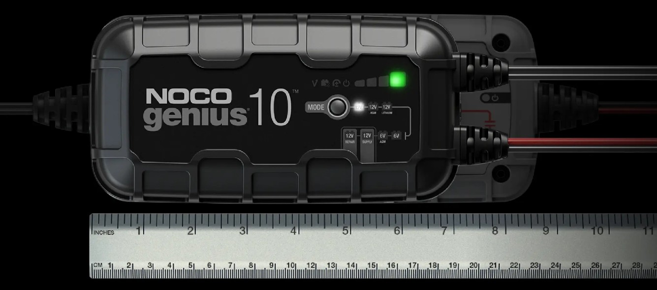 NOCO GENIUS10 charger with dual cables, ruler for scale, showing compact and rugged design.