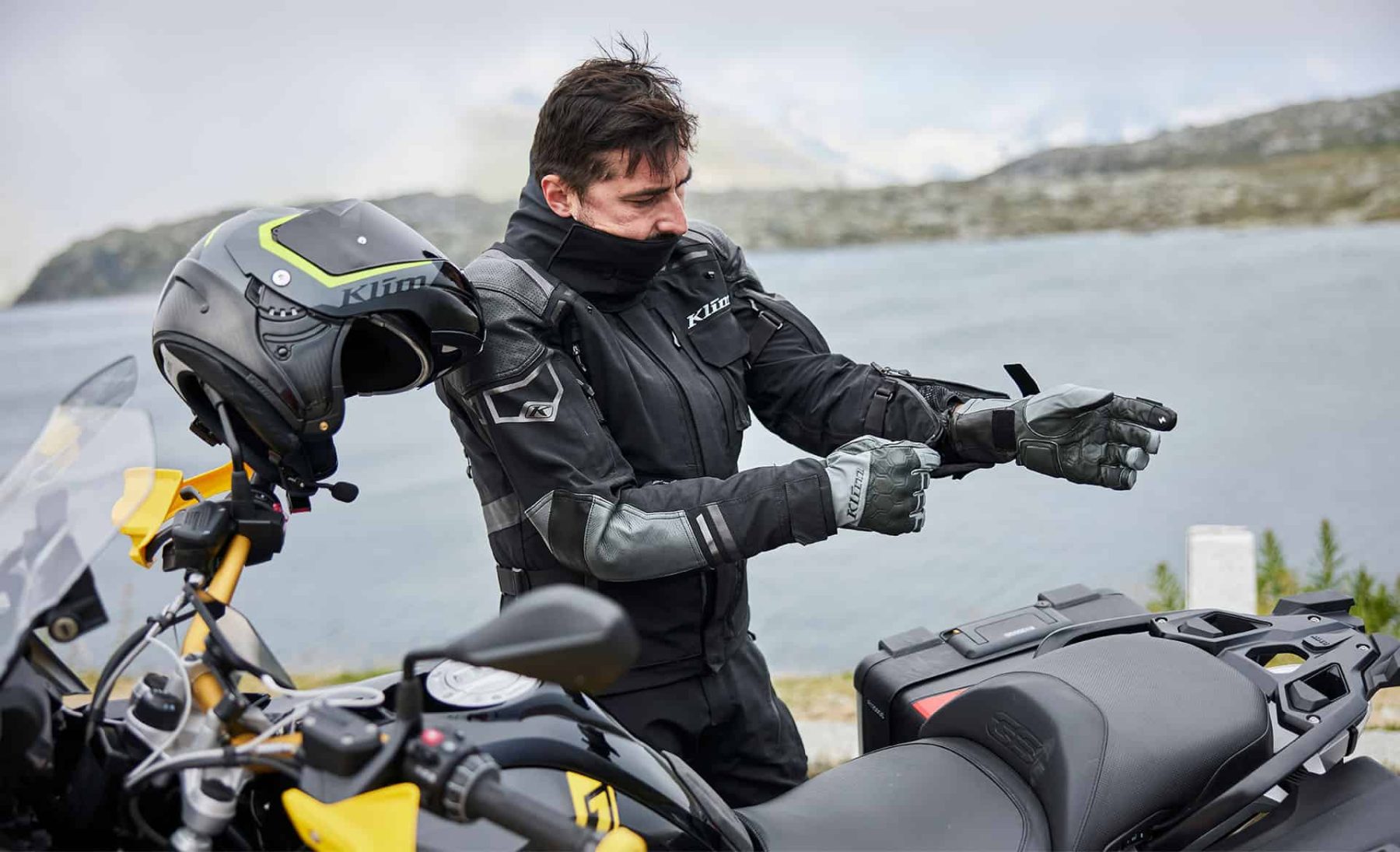 Motorcyclist in winter gear wearing Klim gloves, preparing for cold-weather riding