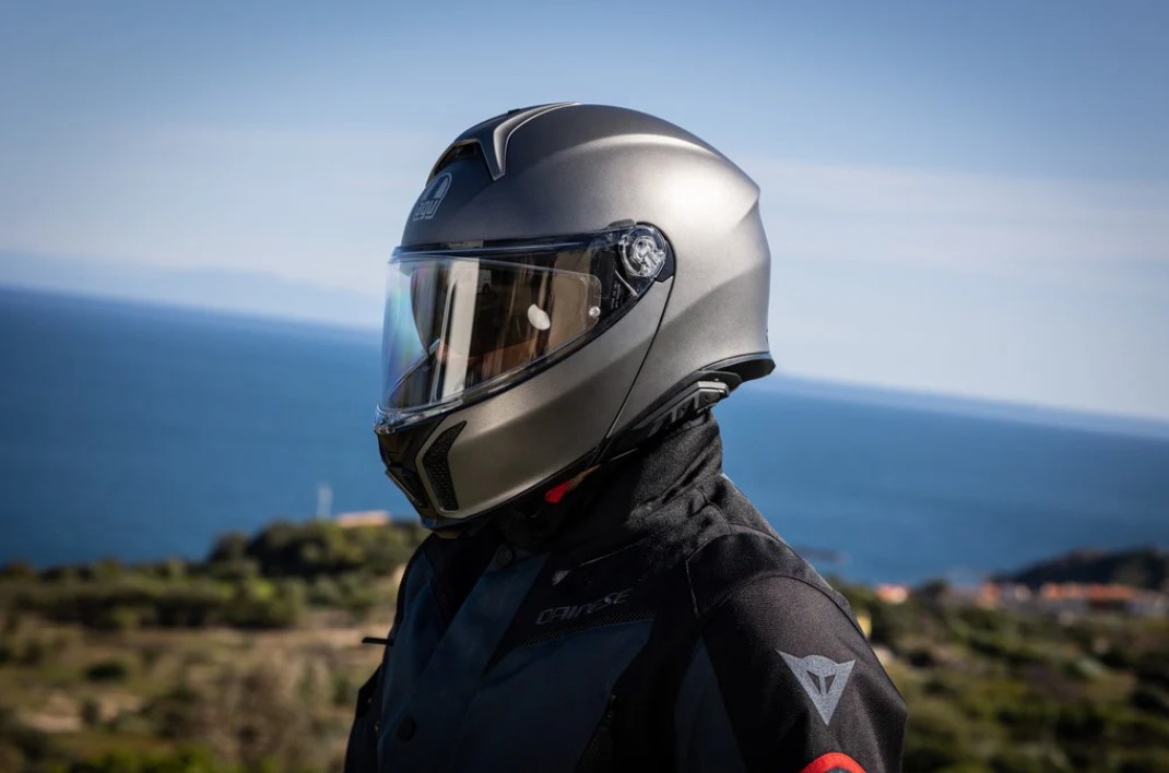 Rider wearing AGV Tourmodular helmet overlooking the coast