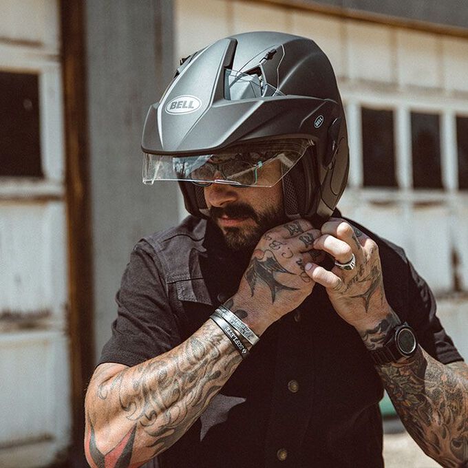 Rider adjusting a Bell Mag-9 Sena open-face helmet while wearing glasses
