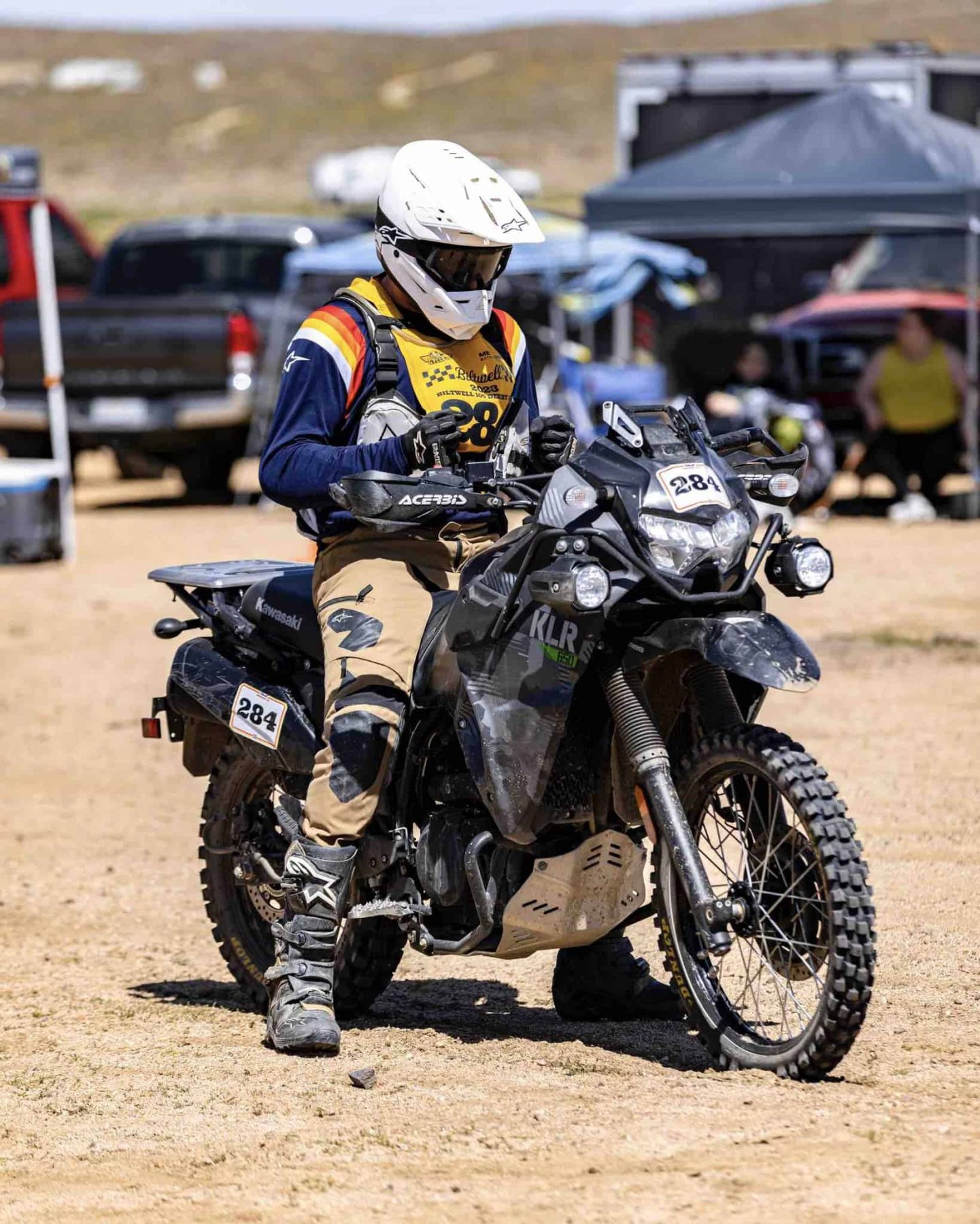 Dual-sport rider on a dirt bike with Dunlop D606 tires on rocky terrainq