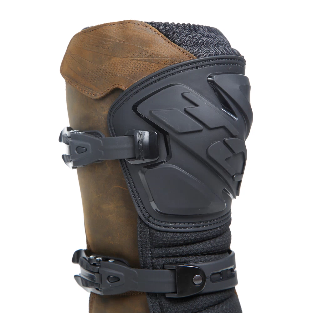 Close-up of a dual-sport motorcycle boot with rugged buckles and padded upper for secure fit and weather protection.