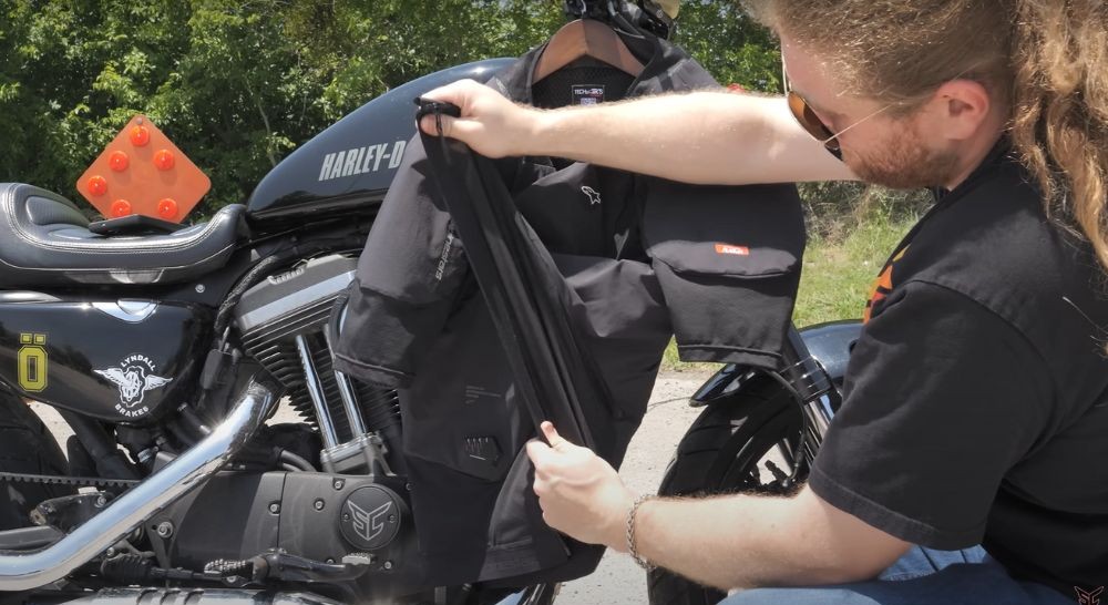 Rider inspecting the stretch mesh and interior build of a Tech-Air 5 Plasma jacket